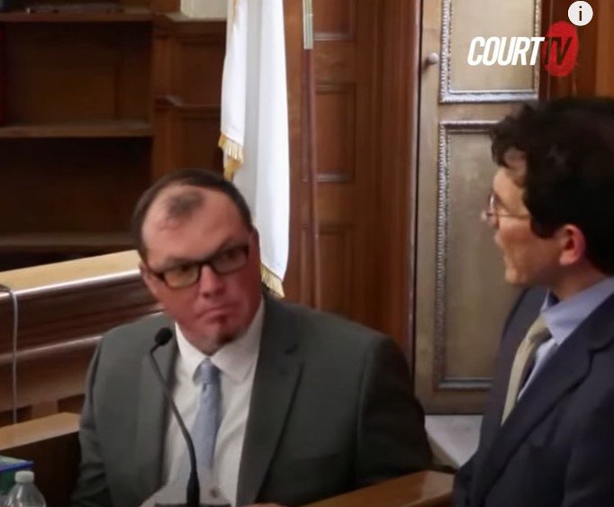 Burgess Burgess on the stand with Alessi standing next to him.
