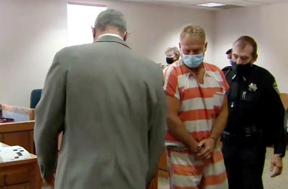 Barry Morphew at hearing in orange and white stripes and a face mask.